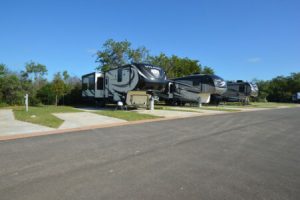 RV's parked in spacious concrete lots at Hardy's Resort RV Park in College Station, Texas.